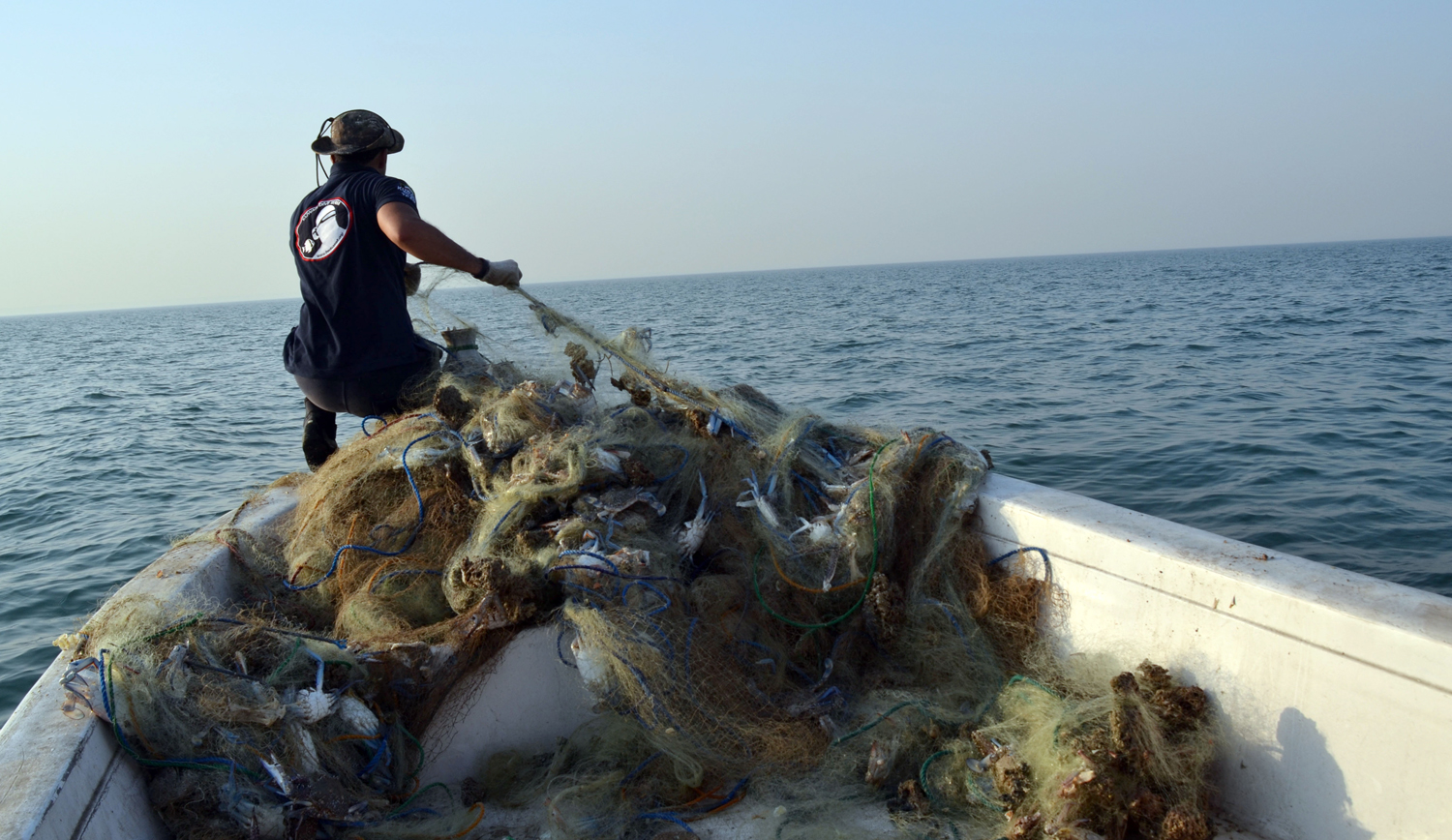 Kuwait divers lift disposable fishing nets on Island