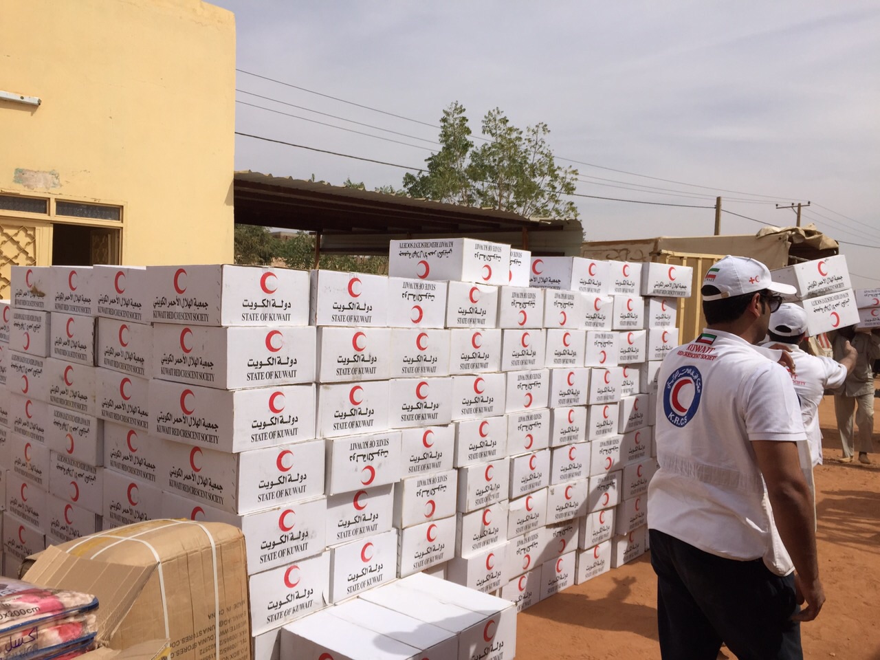 Volunteers of Kuwait Red Crescent Society distribute humanitarian supplies for refugees from South Sudan