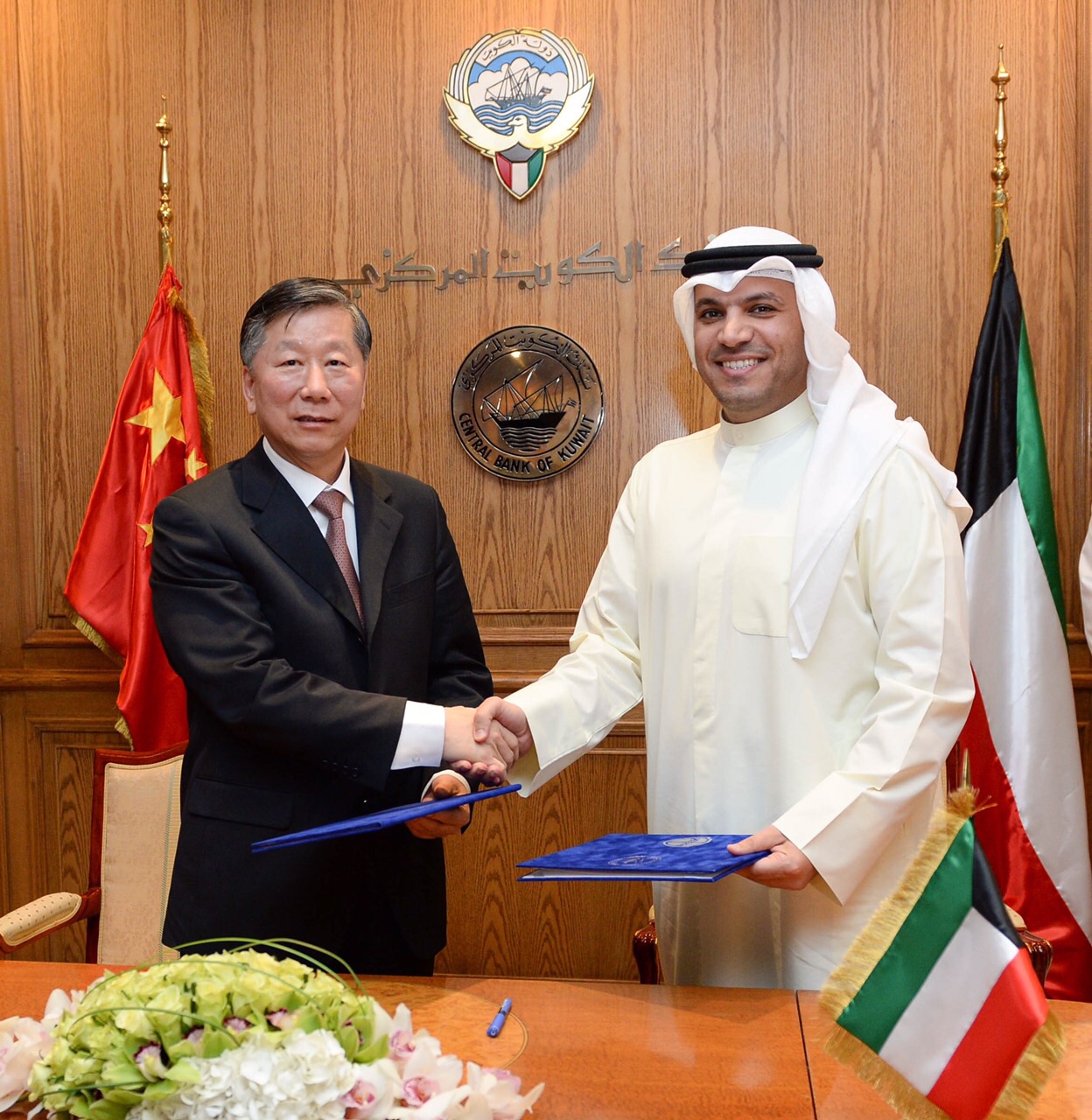 محافظ بنك الكويت المركزي الدكتور محمد الهاشل يصافح ممثل هيئة تنظيم المصارف الصينية