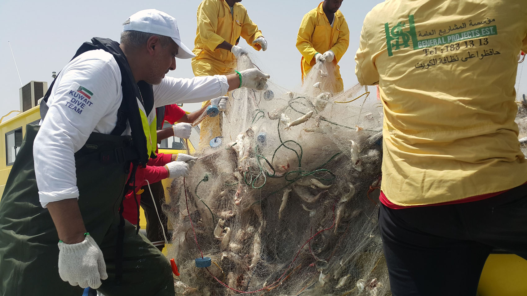 Kuwaiti divers lift fishing nets abandoned in Kuwait Bay