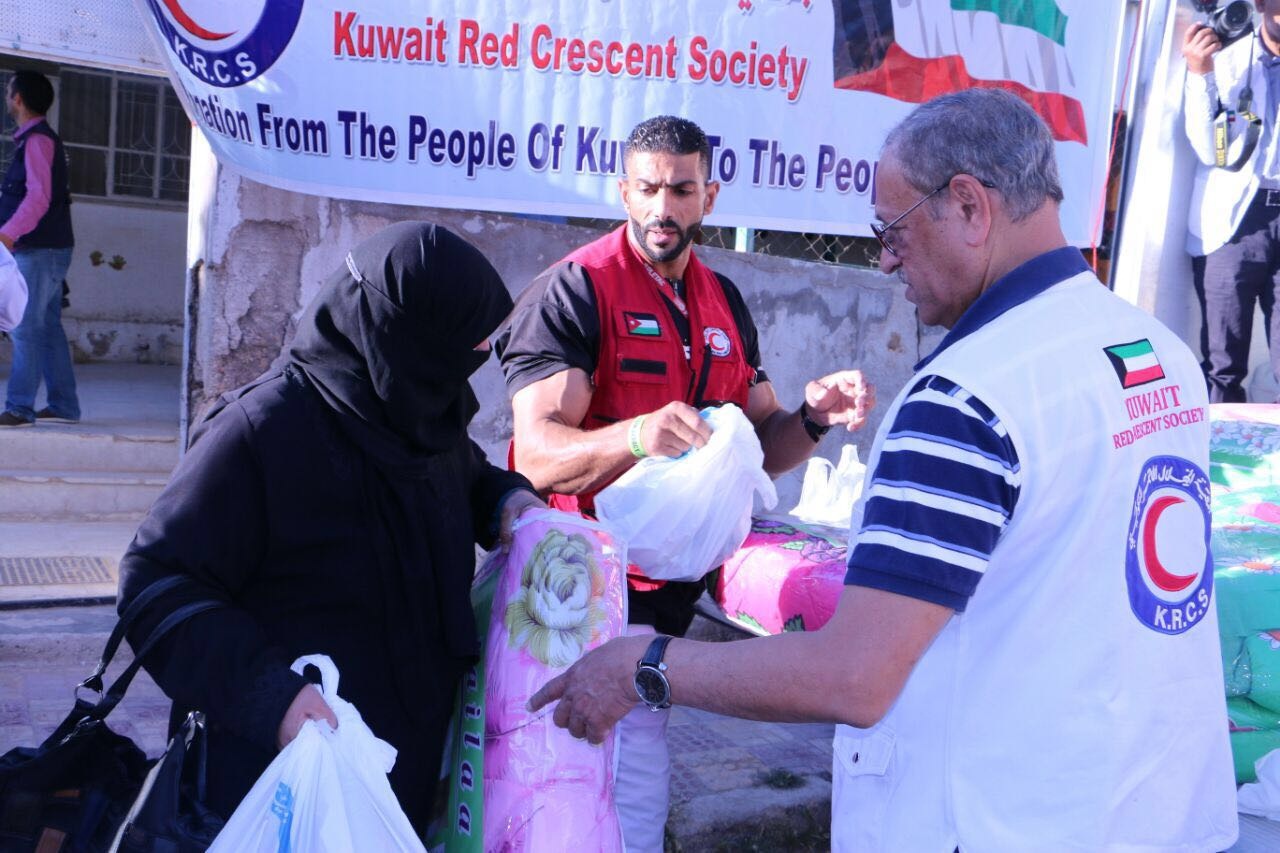 وفد الهلال الأحمر الكويتي اثناء توزيع مساعدات على 500 أسرة سورية لاجئة في العاصمة الأردنية عمان