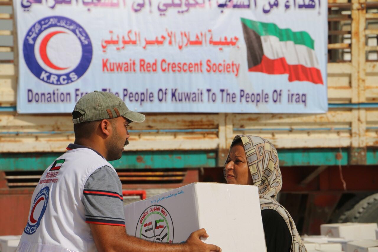 Members of Kuwait Red Crescent Society (KRCS) giving away relief aid boxes to displaced Iraqi families in Anbar