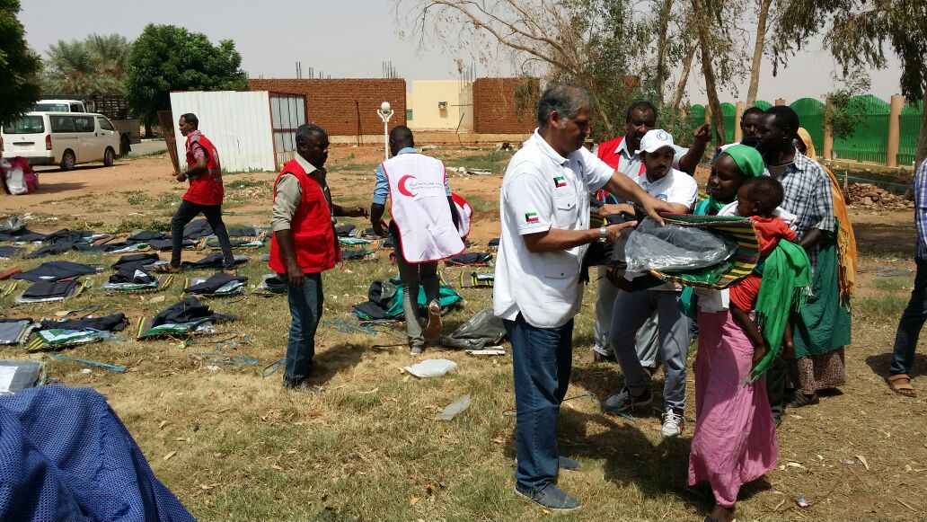 Members of Kuwait Red Crescent Society handing out relief aid to floods victims in Khartoum