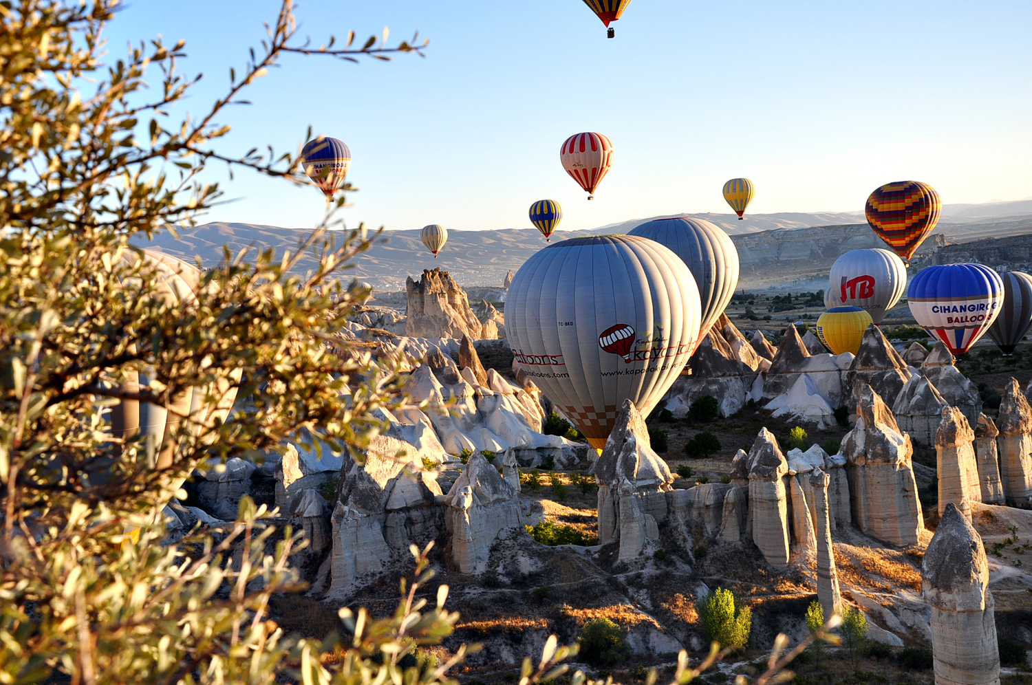 Balloons above mountain peaks in the ancient Turkish region of Cappadocia
