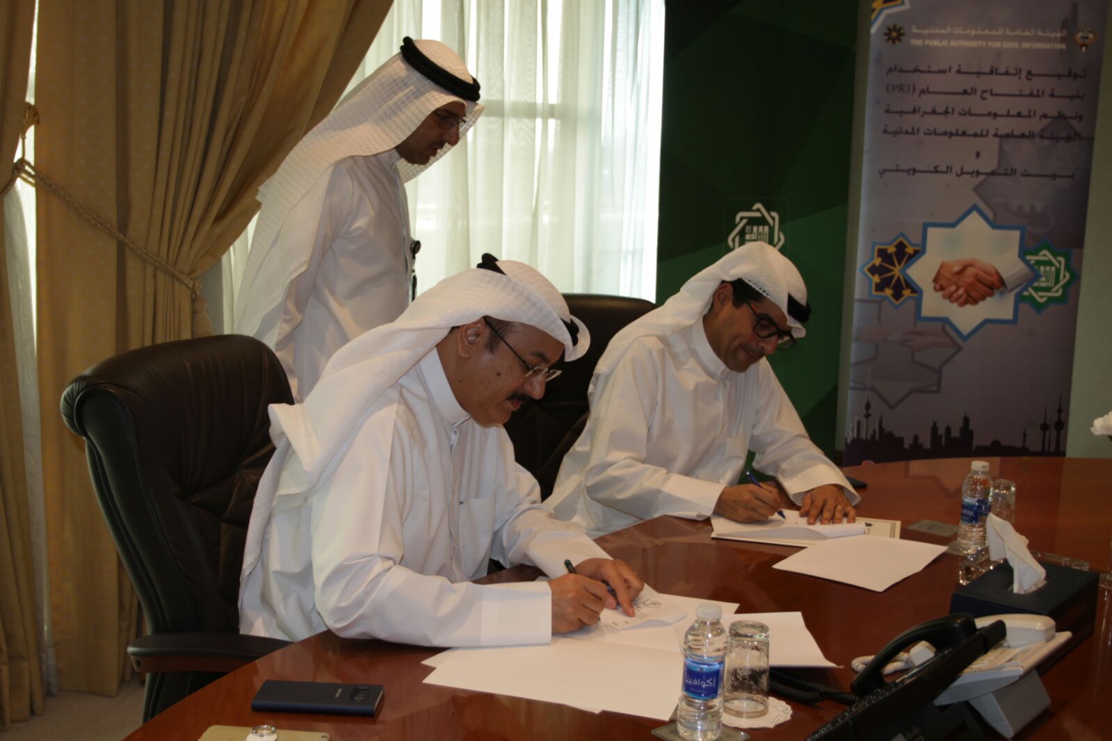 (المعلومات المدنية) و(بيتك) الكويتيان أثناء توقيع مذكرة لتفعيل الخدمات الإلكترونية