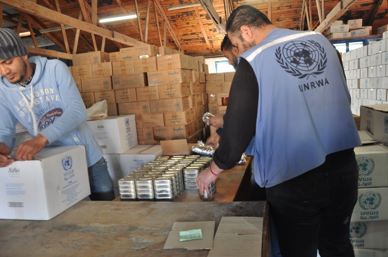 موظفو الاونروا أثناء توزيعهم المعونات علي اللاجئين الفلسطينيين بقطاع غزة