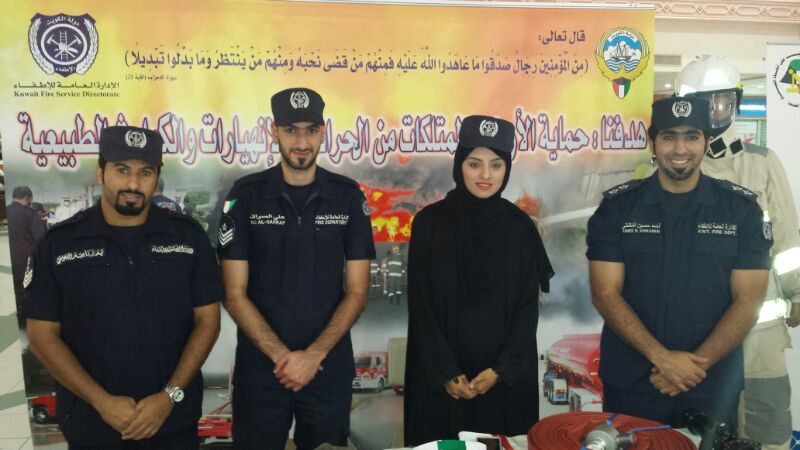 المسؤولة الاعلامية في حملة (الكويت واحة خضراء) التطوعية فاطمة  العنزي تتوسط المشاركين من الادارة العامة للاطفاء  