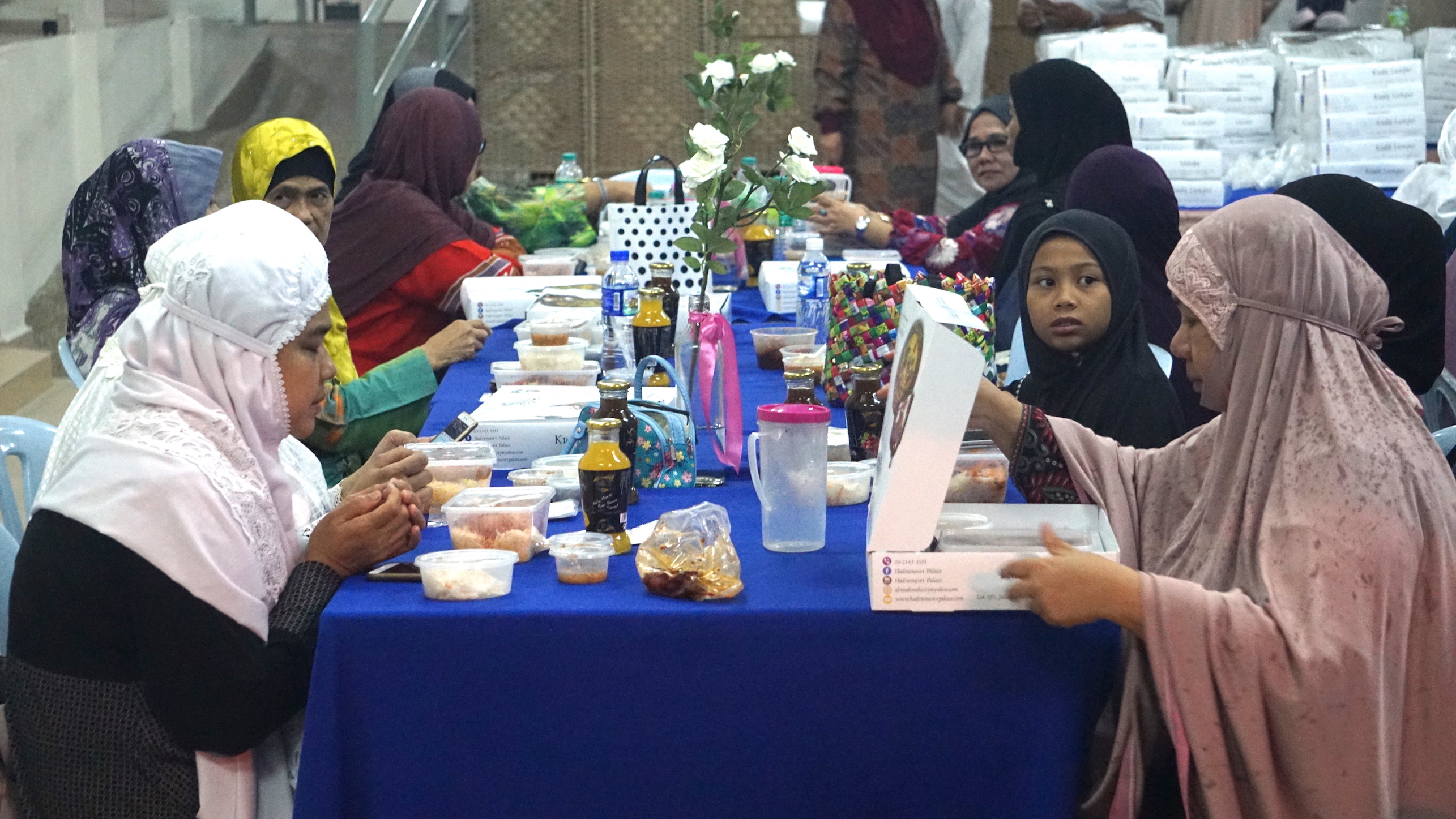 Muslims about to eat their iftar meal which was distributed by Kuwait's embassy in Malaysia as part of a charity project to provide more than 5,300 iftar meals to mosques, orphanages, schools and other places