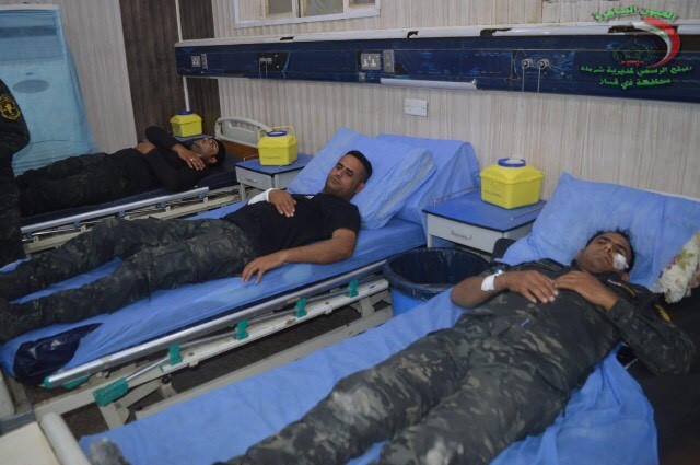 Several police officers lay in a Dhi Qar hospital after protesters hurled stones at them