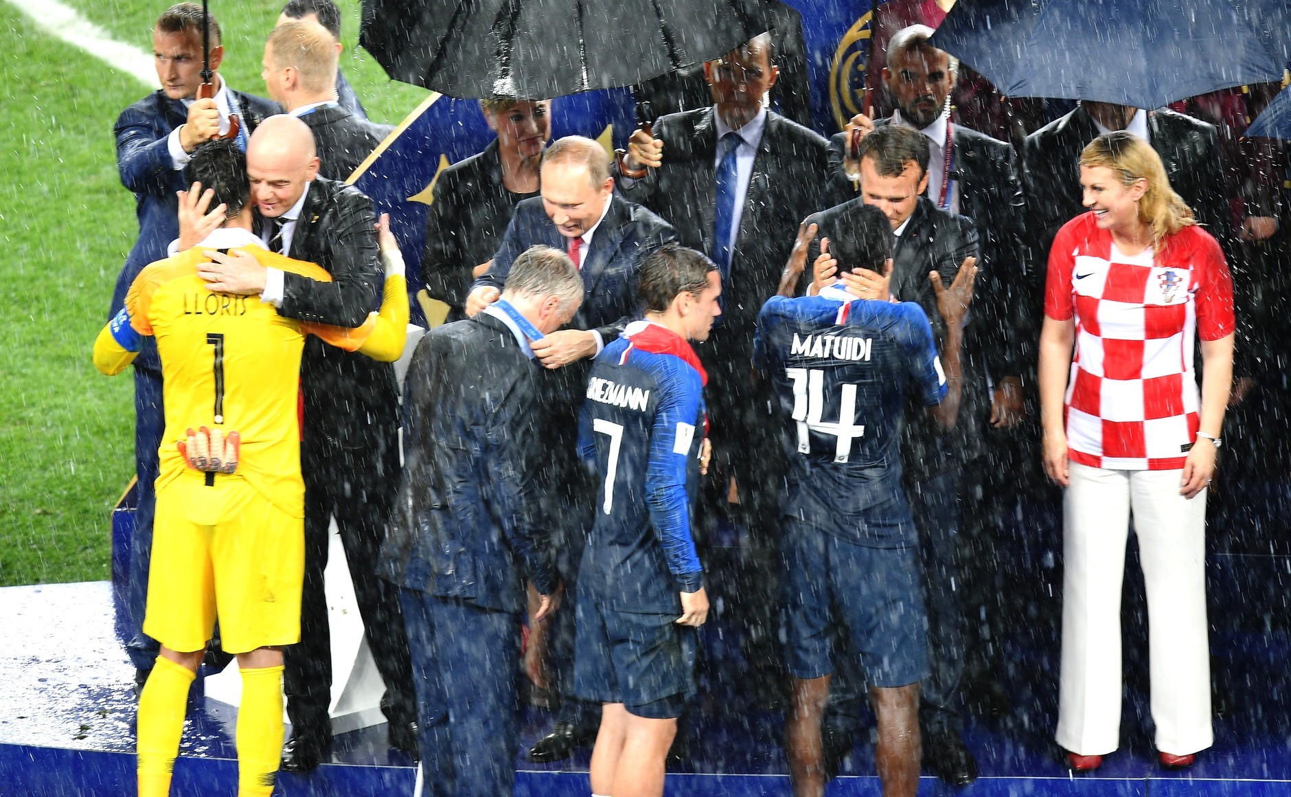 الرئيس الروسي فلاديمير بوتين يوزع الميداليات على المنتخبات الفاىزة تحت الأمطار الغزيرة