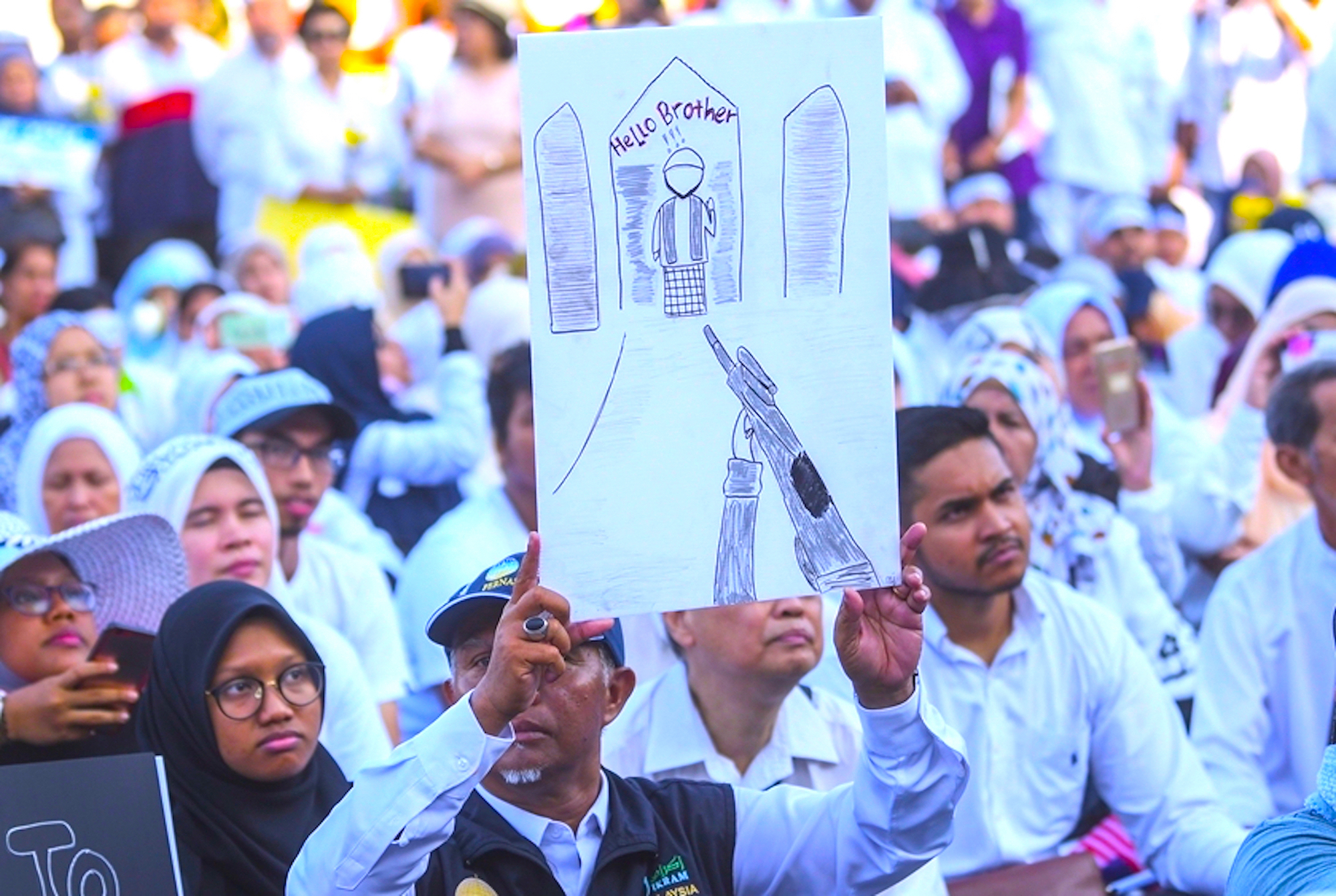 مجموعة من المتظاهرين يحملون رسم للمقولة الشهيرة في مجزرة نيوزيلندا ”مرحبا أخي“