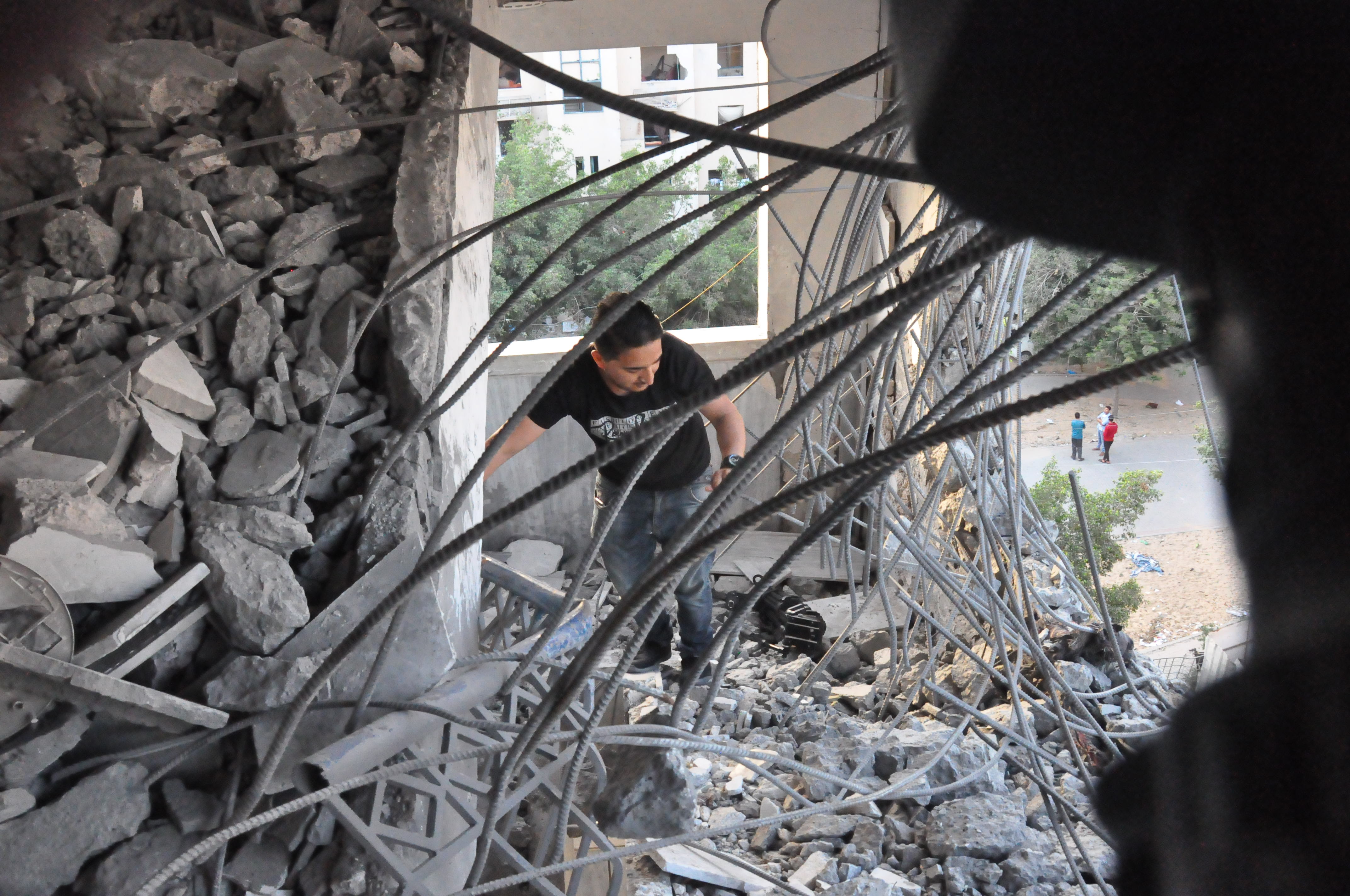 فلسطيني بتفقد اثار منزله المدمر جزئيا بغزة