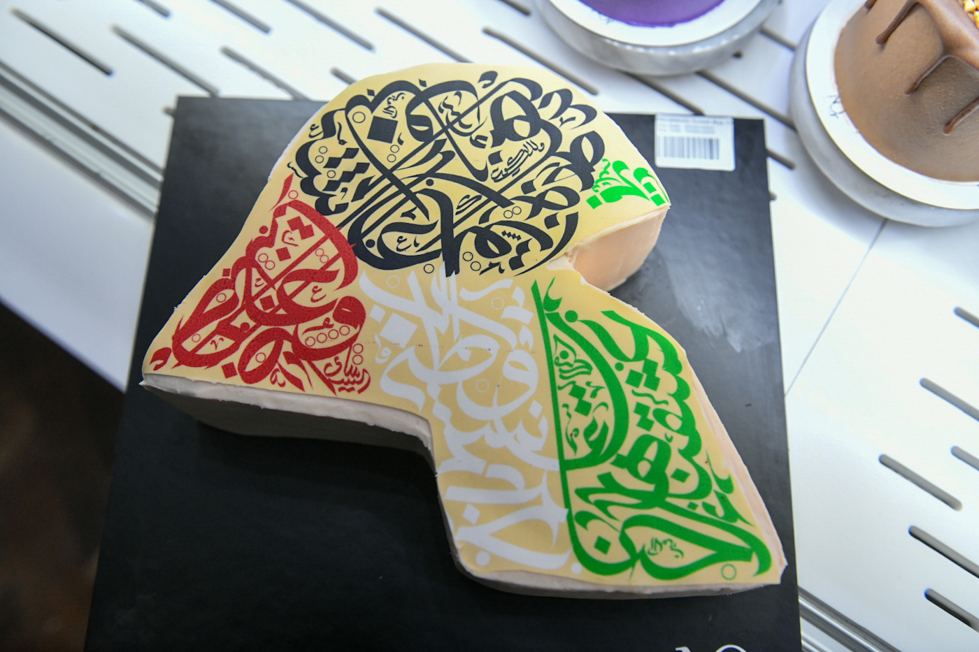 Kuwaiti map painted on a slice of cake and decorated with colors of Kuwaiti flag