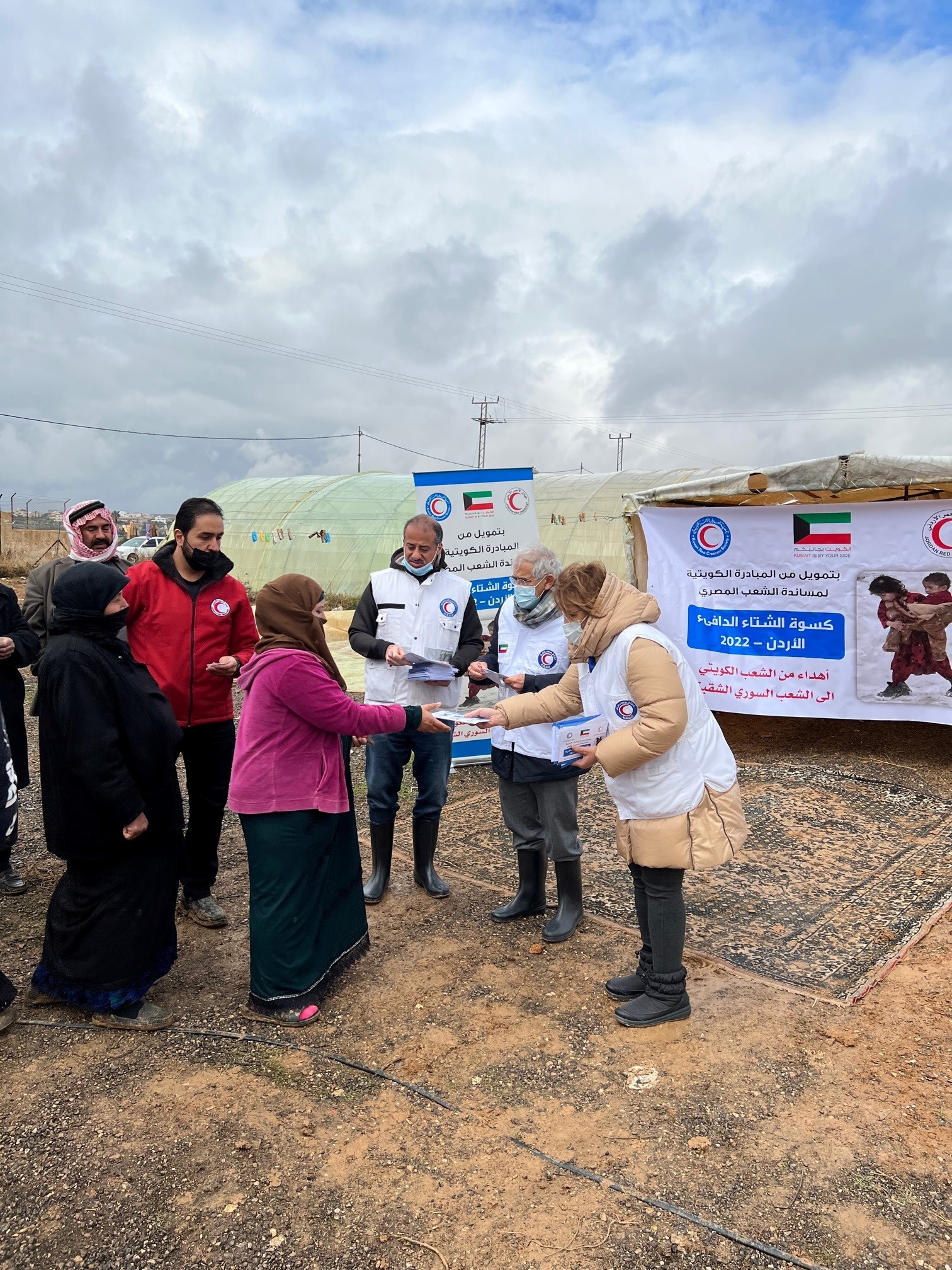 أعضاء جمعية الهلال الأحمر الكويتي خلال توزيع (كسوة الشتاء) والمساعدات على 1200 أسرة سورية لاجئة في الأردن
