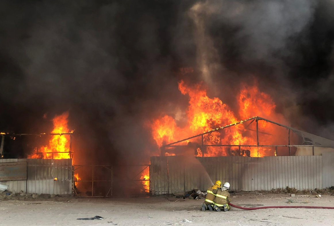 فرق الاطفاء اثناء محاولة إخماد النيران في سوق الخيام بمنطقة الري