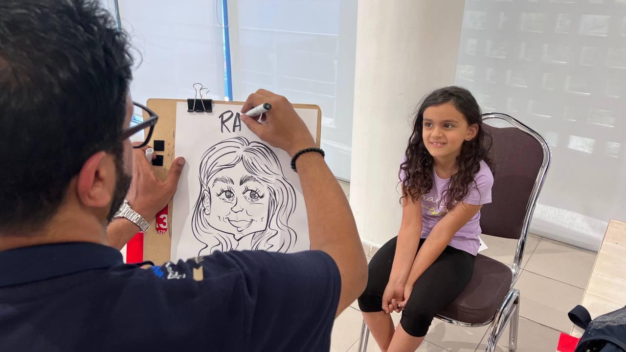 The Kuwaiti caricaturist Mohammad Al-Qahtani draws for visitors of the first caricature exhibition