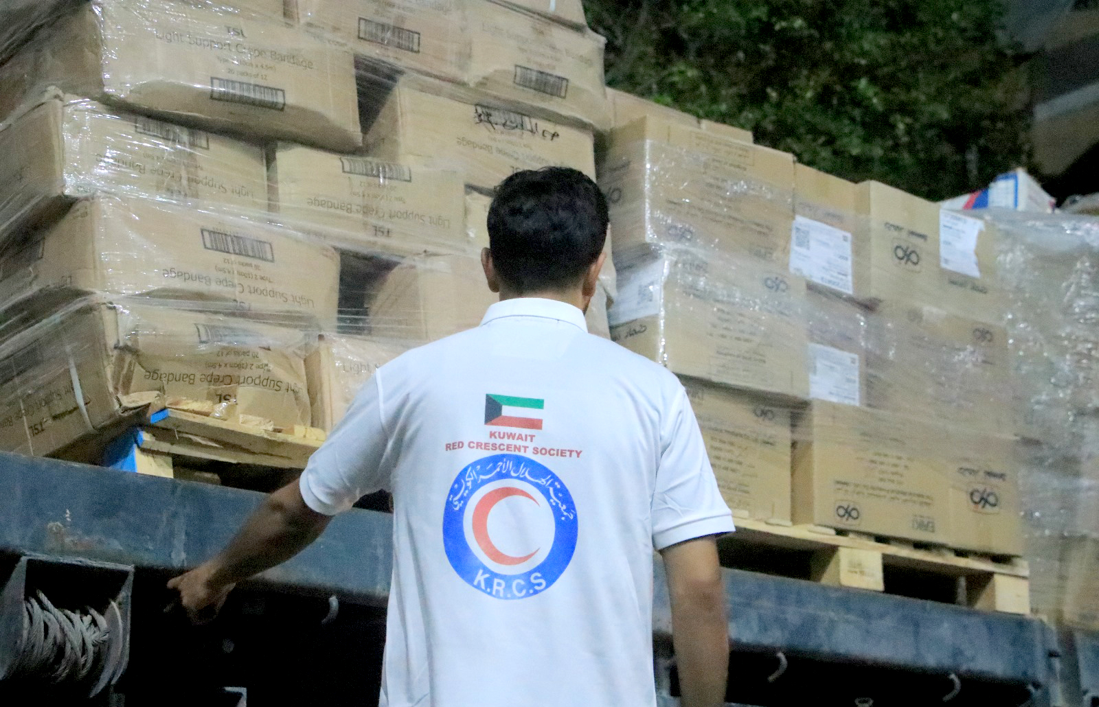 Kuwait Red Crescent Society's (KRCS) volunteers handing out relief supplies