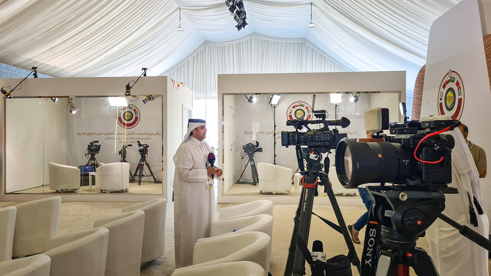 A reporter reporting live at the media center of the 44th GCC Summit