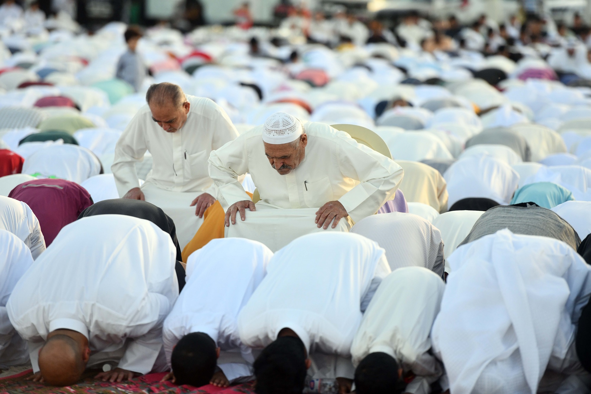 Men, elderly, women, and children perform Eid prayers