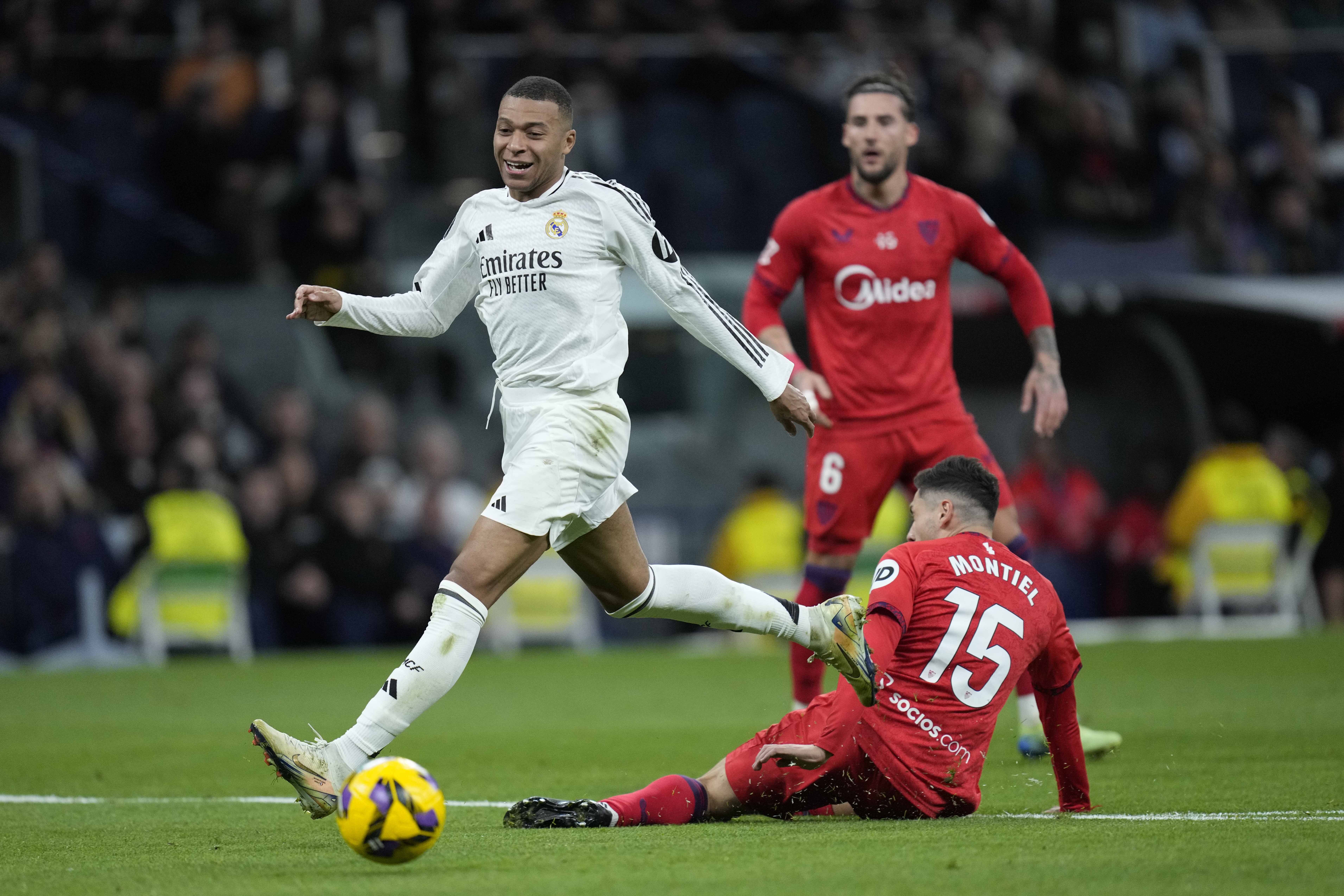 لاعب ريال مدريد يتنافس على الكرة مع لاعب إشبيلية