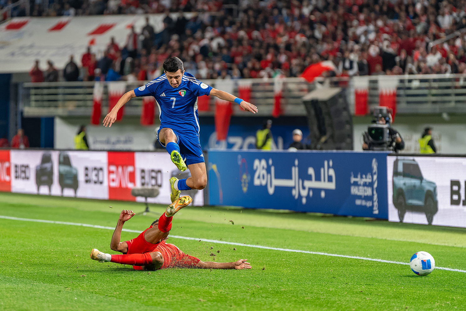 لاعب البحرين يستخلص الكرة من امام لاعب الكويت