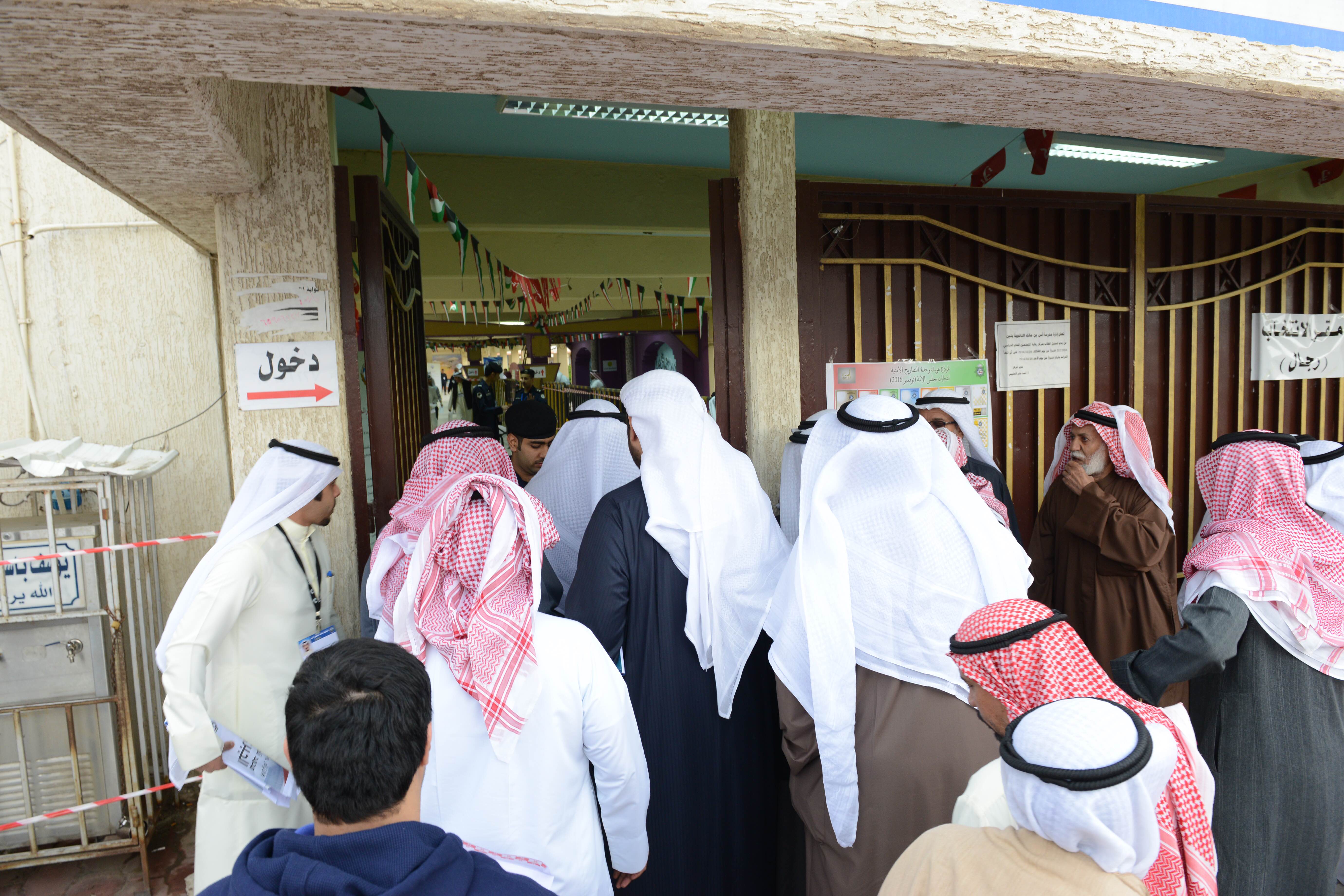 Des électeurs rassemblés devant un bureau de vote.