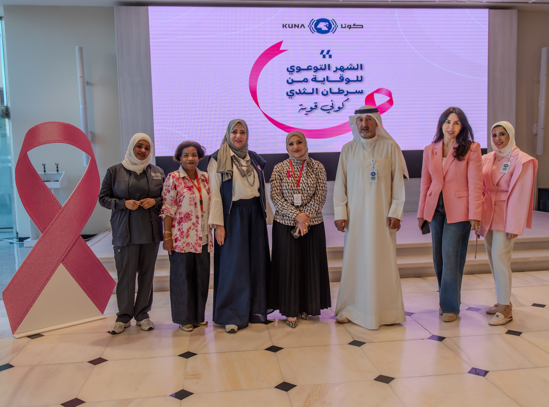 Director of Marketing and Public Relations Department Esam Al-Ruwayeh with KUNA employees and members of the "First Step" Volunteer Team