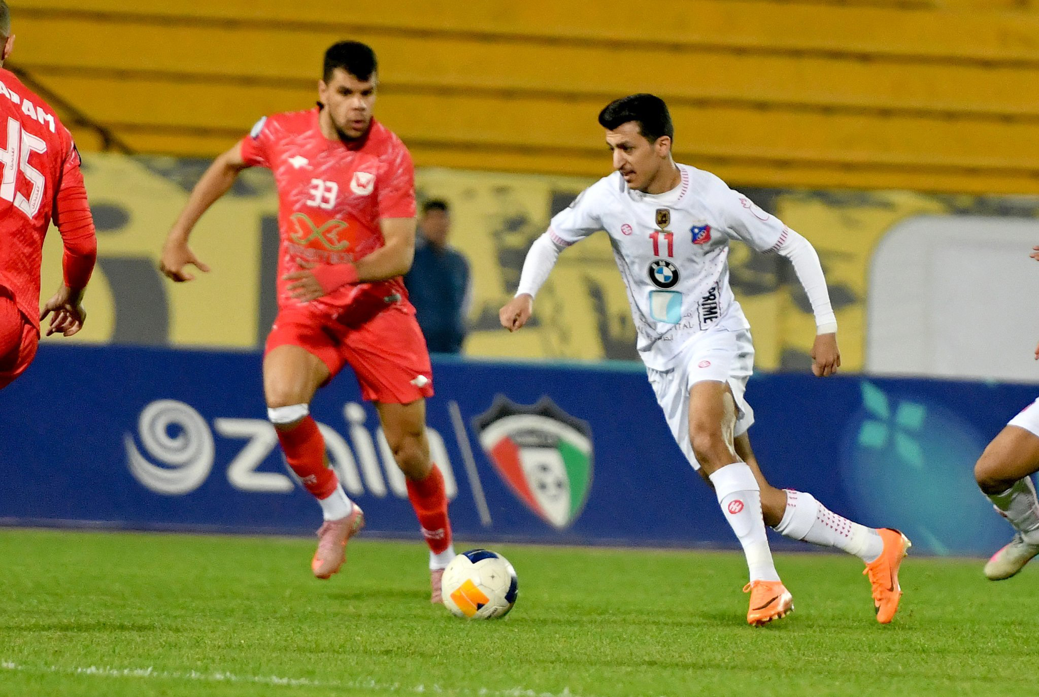 لاعب الكويت ينطلق بالكرة وسط متابعة من لاعبي الفحيحيل