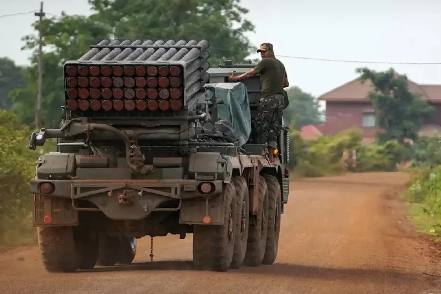 جندي يقف فوق منصة إطلاق صواريخ متعددة خلال تحرك آلية عسكرية على طريق حدودي ترابي وسط تصاعد التوتر بين تايلاند وكمبوديا