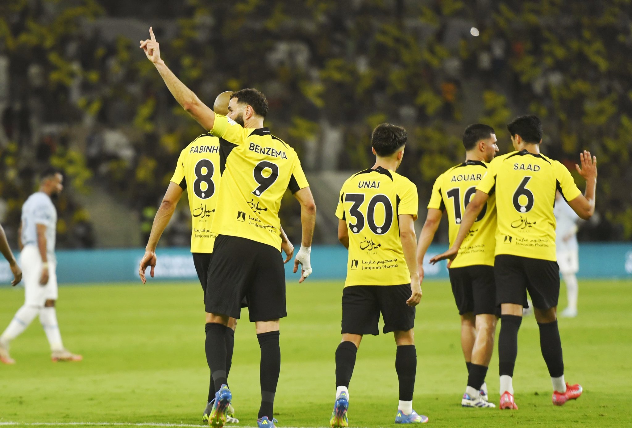 بنزميا وزملائه في الفريق يحتفلون بالهدف