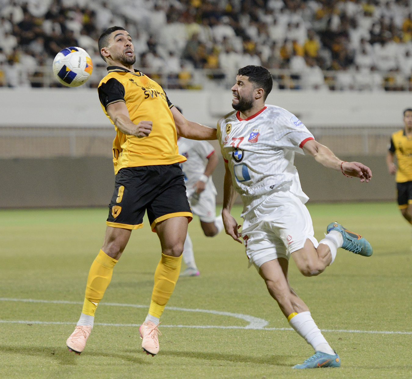 لاعب القادسية يحاول السيطرة على الكرة وسط مضايقة من لاعب الكويت