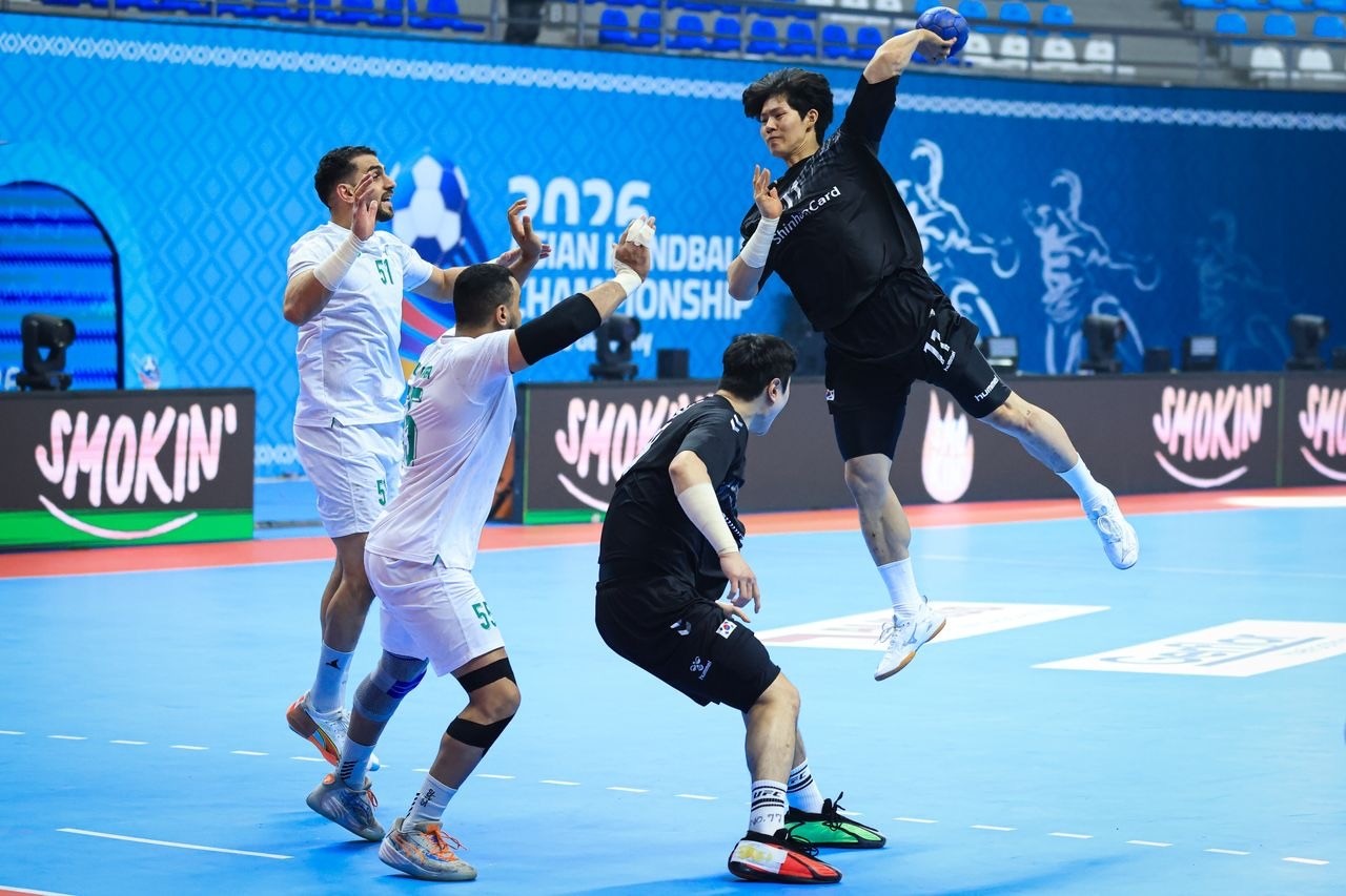 لاعبو السعودية يحاولون منع اللاعب الكوري من التصويب على المرمى