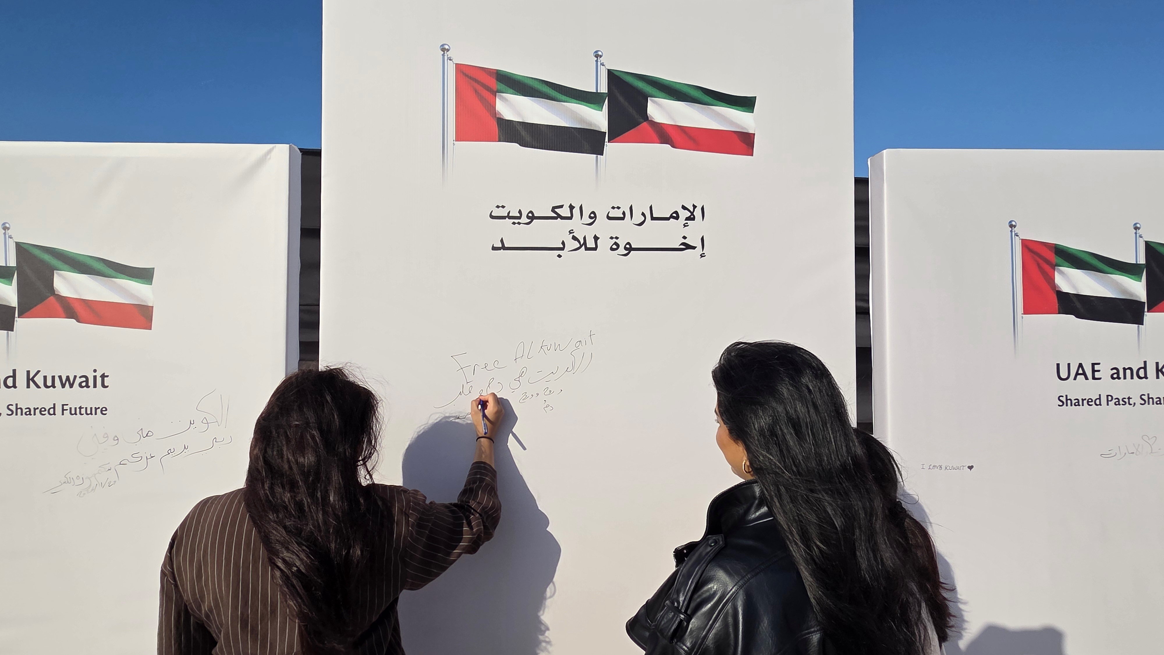 مشاركات يدون مشاعرهن الصادقة تعبيرا عن المحبة والامتنان لدولة الامارات في مشهد انساني عفوي ضمن فعالية (الكويت في دارها)
