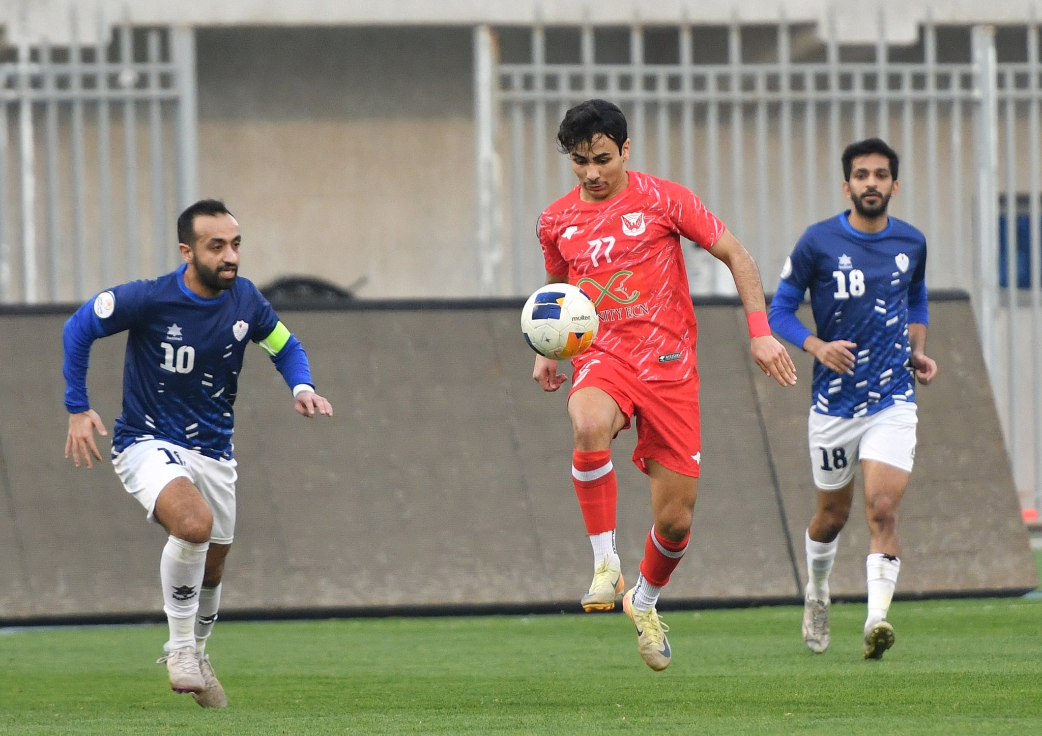 لاعب الفحيحيل يحاول السيطرة على الكرة وسط متابعة من لاعب الشباب