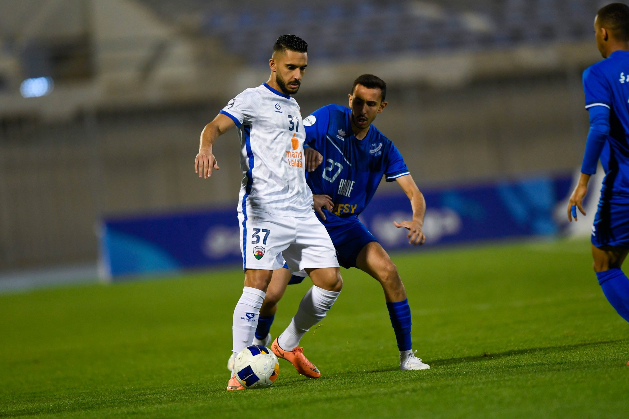 لاعب الجهراء يحاول الحفاظ على الكرة وسط مضايقة من لاعب التضامن