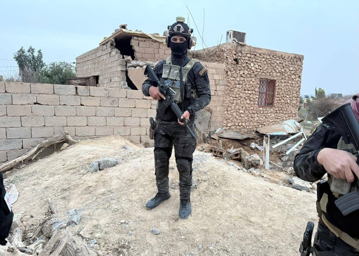 An Iraqi National Security officer stands amidst the rubble of a building where three terrorists committed suicide in Anbar
