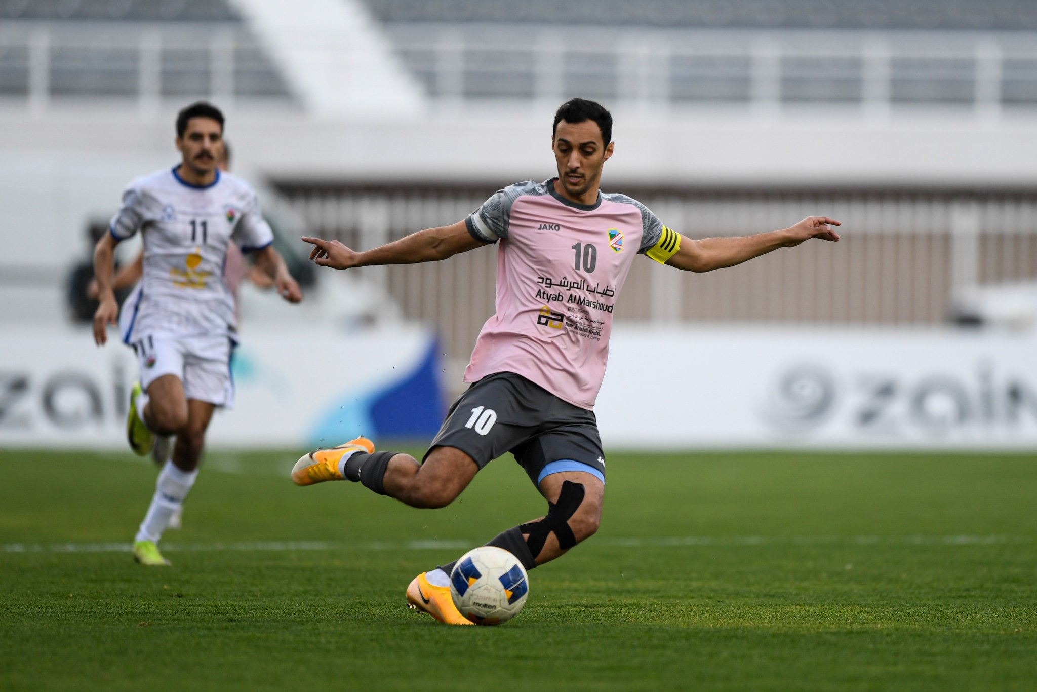 لاعب السالمية يحاول تمرير الكرة في وسط الملعب